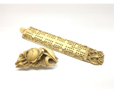 An ivory brooch of floral form and a bone carved cribbage board with sticks.