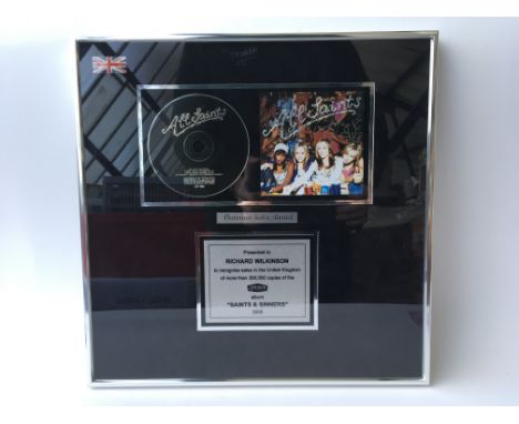 An All Saints framed platinum sales award presented to Richard Wilkinson, including a signed album cover of Saints and Sinner