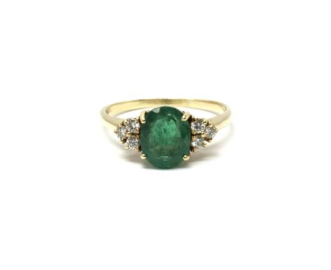 A ladies 18ct gold ring set with a central emerald flanked by three diamonds to either side. Total weight approx 3.7 grams, r