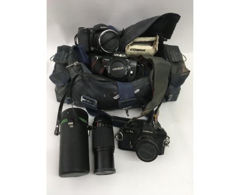 A bag of cameras including a Minolta and a Cosina with lens