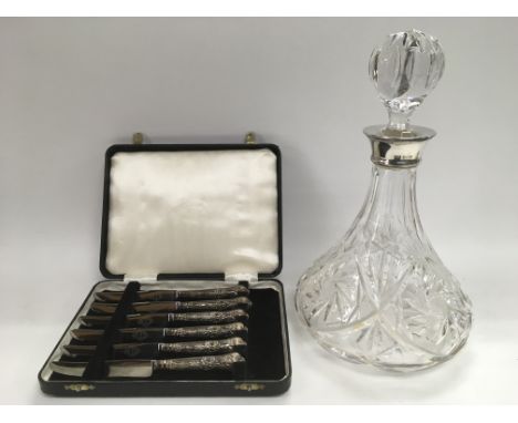 A cased set of six silver handled butter knives together with a silver collared ship's decanter.