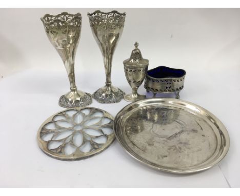 A collection of silver comprising a pair of bud vases , cruet salt cellar, card tray and a teapot stand