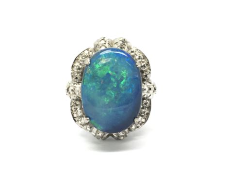 An 18ct white gold ring set with a large central opal surrounded by small diamonds. Total weight approx 7 grams, ring size P.