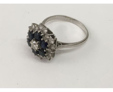 An unmarked, white gold sapphire and diamond cluster ring.Approx R