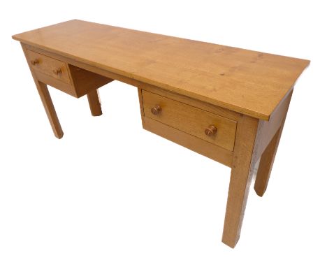 A good modern light oak side table; the slightly overhanging top above kneehole space and two drawers flanking, raised on squ