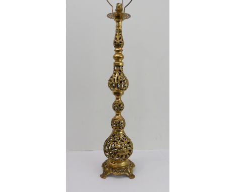 A heavy pierced brass table lamp of Moorish candle form: openwork leaves and scroll-style decoration on stand with four cast 