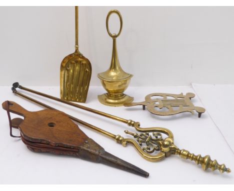 Four fireside tools and a brass doorstop:brass trivet, shovel and tongs;oak bellows;the doorstop of vase form (29 cm high).