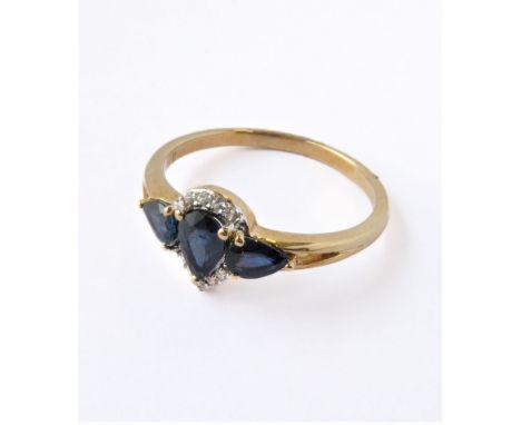 A lady's yellow gold (marked '375') dress ring: centrally set with an inverted pear-shaped hand-cut sapphire flanked by two f