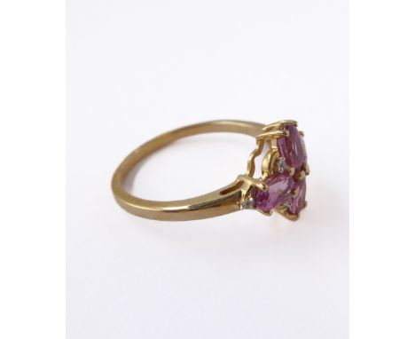 A lady's 9-carat yellow gold dress ring: set with four amethyst coloured high-cut stones, flanked by small white chips, ring 