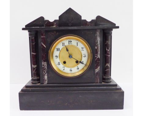 A late 19th century black slate and marble eight-day mantle clock; the cream chapter ring with Arabic numerals flanked by ros