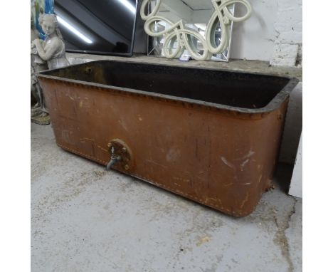 A large riveted cast-iron trough/tank with tap, L142cm, H55cm, D70cm 