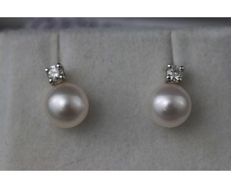 A white metal two stone pair of cultured pearl and diamond stud earrings. Total diamond weight 0.10ct. Post and scroll fittin