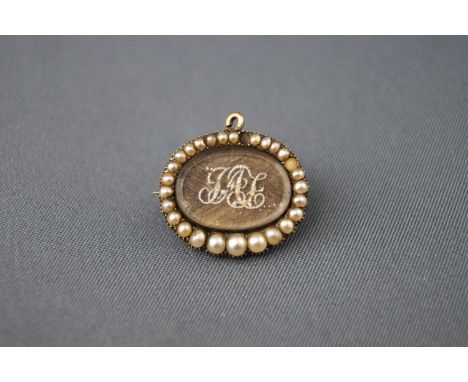 A 19th century gold and half pearl mourning brooch with plaited hair and pearl set initials. Tests indicate gold of at least 