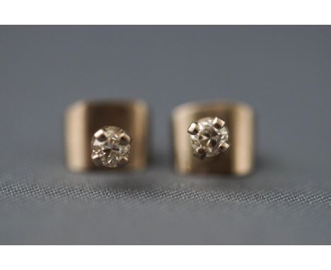 A pair of white metal single stone diamond stud earrings. Approx 0.15ct total diamond weight. Post and scroll fitting. Tests 