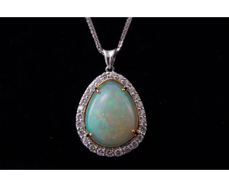 A white metal opal and diamond cluster pendant. Having a pear cut cabochon opal of approx 9.50cts together with round brillia