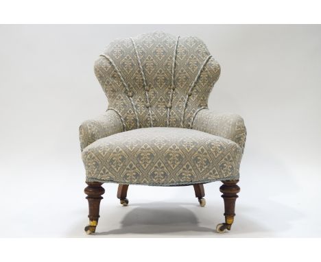 A Victorian button back nursing chair with shell shaped back, raised on turned mahogany front legs, 75cm high overall