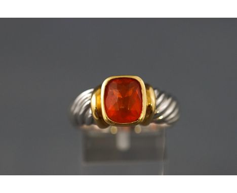 A yellow and white metal single stone ring set with a cushion cut faceted fire opal. Stamped 18K 750. Size: T 12.0 grams