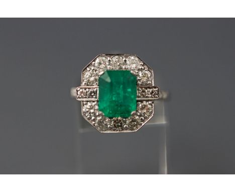 A white metal cluster ring set with a rectangular cut emerald approx 3.03ct together with round brilliant cut diamonds approx