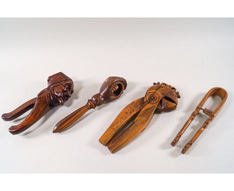 Treen: A Continental wooden nutcracker, carved in the form of a man's head, a Folk Art nutcracker, one carved as a hand and a