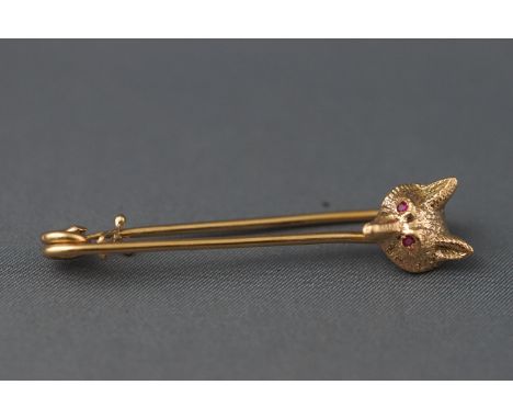 A yellow metal safety pin with fox head design having ruby set eyes. Hallmarked 9ct gold, London, 1972 7.0 grams