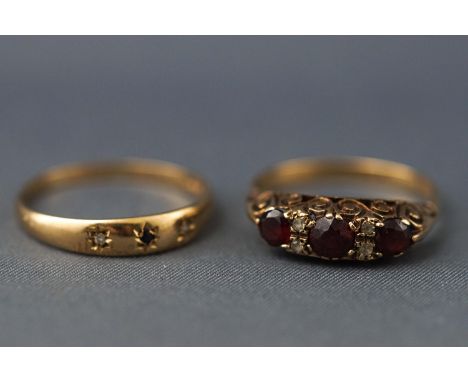 A yellow metal carved half hoop garnet and CZ ring, stamped '9' for 9ct, size: R together with a yellow metal gypsy set sapph