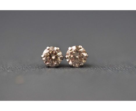 A white metal pair of single stone diamond stud earrings. stated 0.30ct total weight. Post and fitting with plastic backs. St