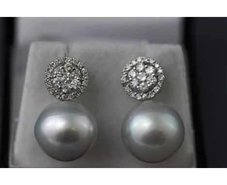 A white metal pair of South Sea pearl and diamond drop earrings. Approximately 1ct total diamond weight. Post and scroll fitt