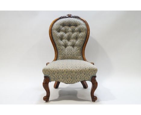 A Victorian walnut button back nursing chair with spoon back on cabriole legs