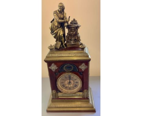 A large mahogany and brass mantle clock with a cast brass figure of William Shakespeare writing at a lectern and with books o