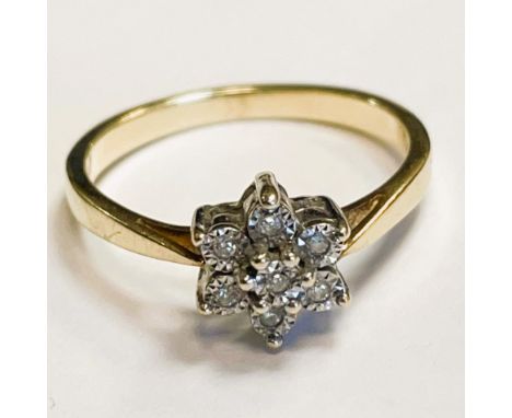 A diamond ring set in a flower shape set in gold metal. Approximately 0.03ct. Ring size M. Approximately 2 grams.