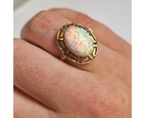 Oval opal ring. A single opal set in a Grecian design setting of 14ct gold (marked 585). Opal approximately 14 x 10mm. Ring s