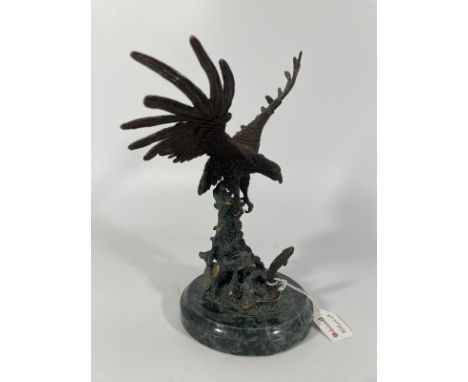 A bronze group of an eagle about to catch a leaping salmon. Approximately 25cm tall with good patina.