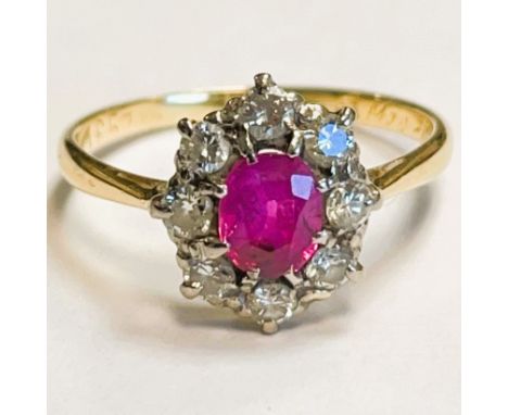 Oval ruby type stone and diamond ring. Single ruby type stone surrounded by eight diamonds set in 18ct gold. Size N. Approxim