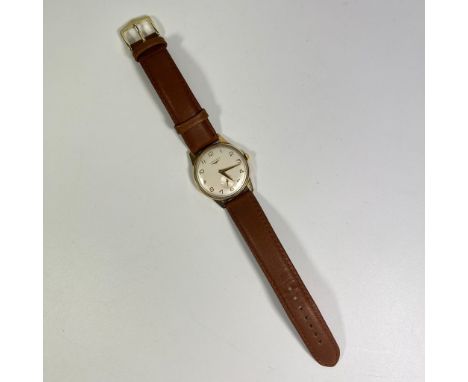 A gentlemans 9ct yellow gold Longines manual wind wristwatch on a leather strap. Approx 33mm case. Total approx 31grams in go