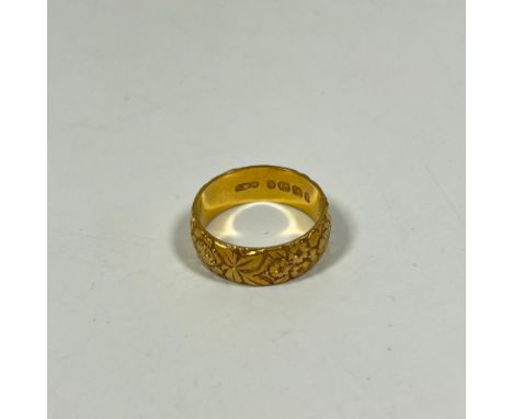 A Hallmarked 18ct yellow gold foliate engraved band ring, size T approx 9grams band width approx 7mm.