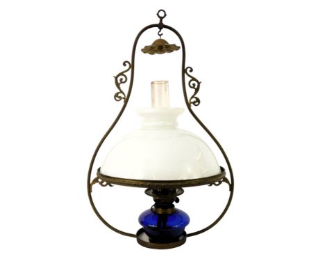 A Victorian hanging oil lamp, with milk glass shade, chimney, and Bristol blue glass reservoir, on a scrolling franc, 70cm hi
