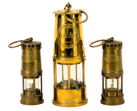 A Protector Lamp and Lighting Company brass miner's lamp, type 6, with ring handle, 23cm high, together with two miniature br