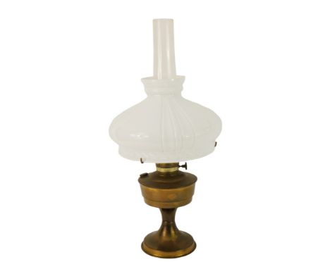 A 20thC oil lamp, with milk glass shade, chimney, with a brass central reservoir, on brass circular foot, 62cm high overall. 