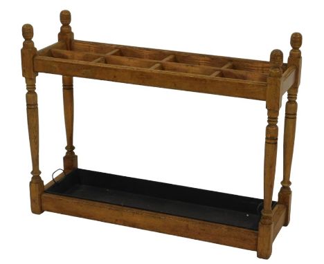 A 20thC oak umbrella or stick stand, eight division, on turned supports, metal two handled drip tray, 72cm high, 91cm wide, 3