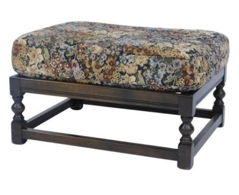 An Ercol dark elm footstool, with floral removable seat, model number 446, 38cm high, 66cm wide, 53cm deep. 