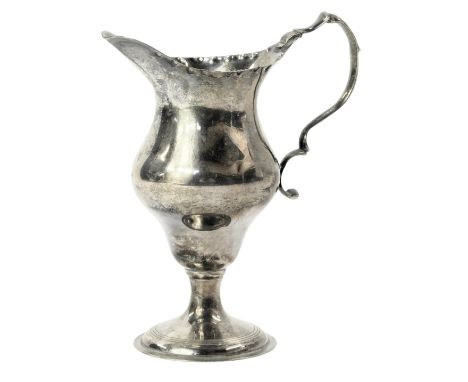 A George V silver pedestal cream jug, with a hammered border and acanthus leaf moulded handle, on circular foot, maker R&amp;