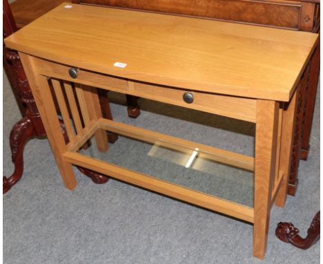 A Treske Furniture bespoke solid oak console table, the bowed rectangular top over a pair of drawers above a glass shelf stre