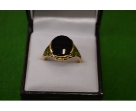 A 9ct gold ring of open work design set with an oval black stone.