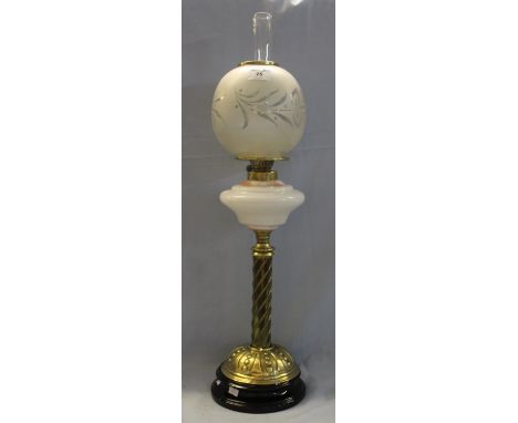 Brass oil lamp with white opaline glass reservoir, repousse brass pedestal base and ceramic support, frosted shade and clear 