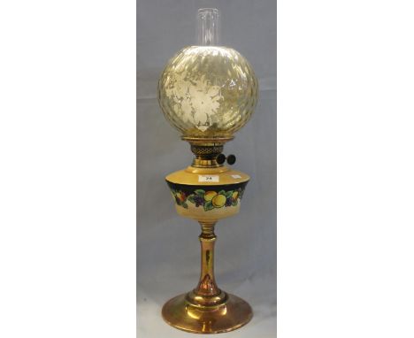 Early 20th Century brass double burner oil lamp with ceramic reservoir, decorated with fruit on a brass pedestal base with sh