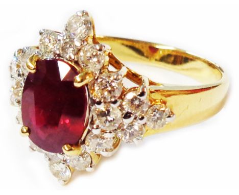 A marked 750 yellow metal ring, set with large central oval ruby within a twenty stone diamond border - size O - boxed