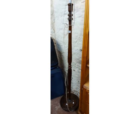 A 20th Century stained wood standard lamp with turned pillar, set on a circular base with squat bun feet