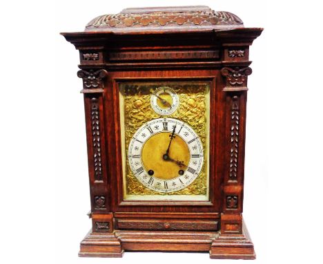 An antique German ornate carved oak cased table clock with regulator dial and brass spandrels to main dial, with Lenzkirch ei