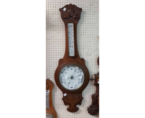 A late Victorian stained oak mounted O. Comitti &amp; Son banjo barometer/thermometer with printed ceramic dial and scale, ap