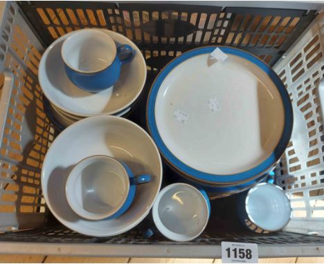 A crate containing a quantity of Denby dinner ware including cereal bowls, plates, cups and saucers, etc.